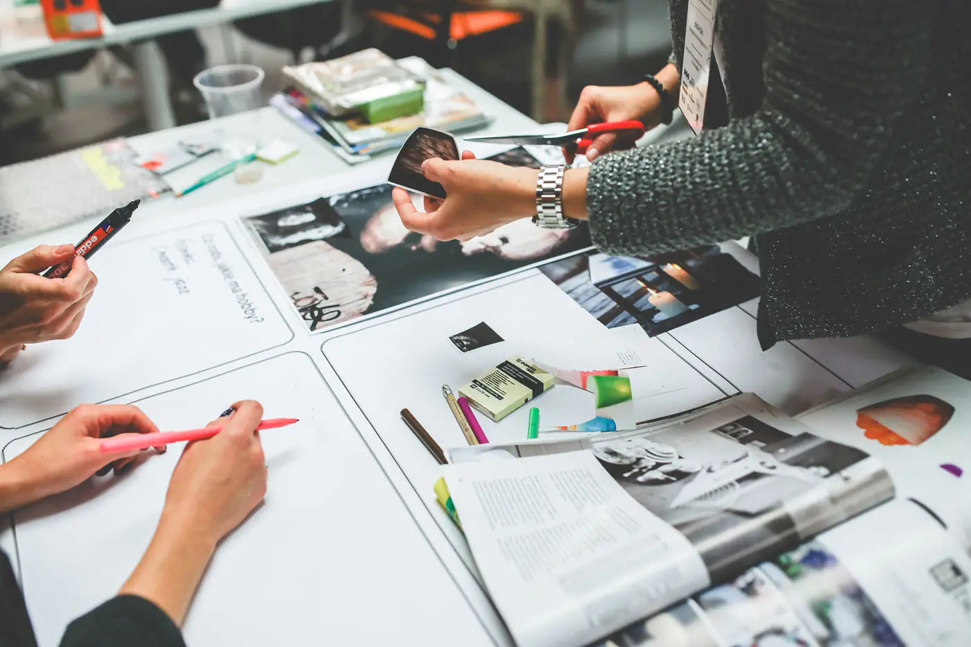 Team members working together over printed layouts on a desk